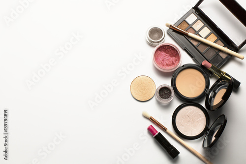 Flat lay of eyeshadow palette,cosmetic brushes and pressed powder. Space for text