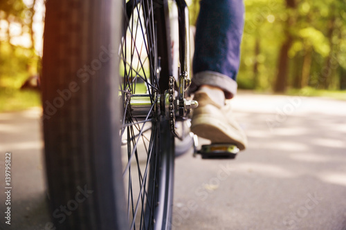 Bicycle wheel and men leg on pedal