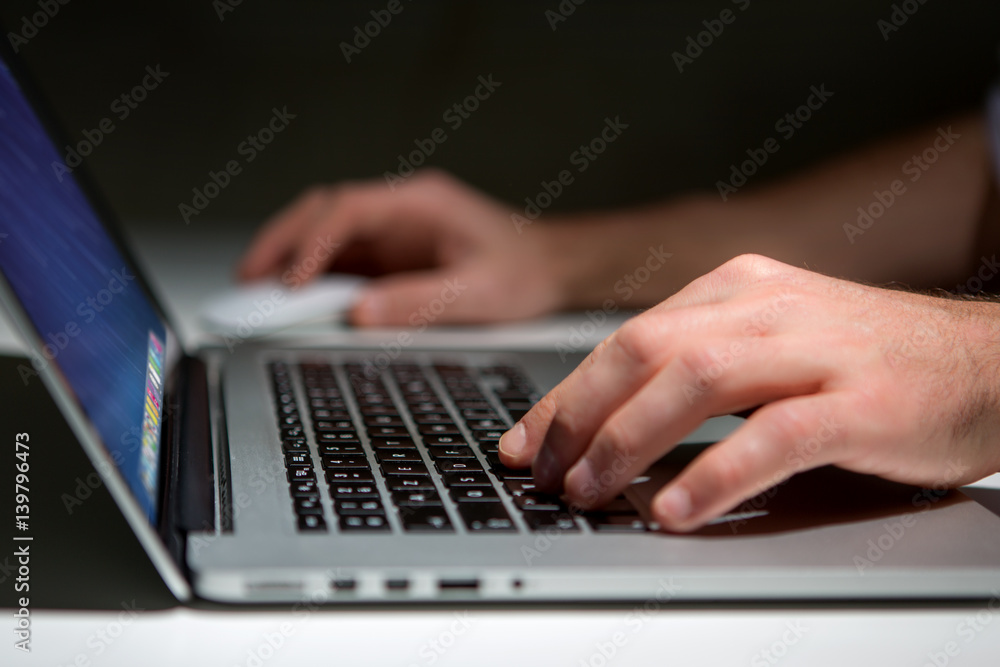 Hand typing on a keyboard of laptop with operating system screen on background Hand typing on a keyboard of laptop with operating system screen on background