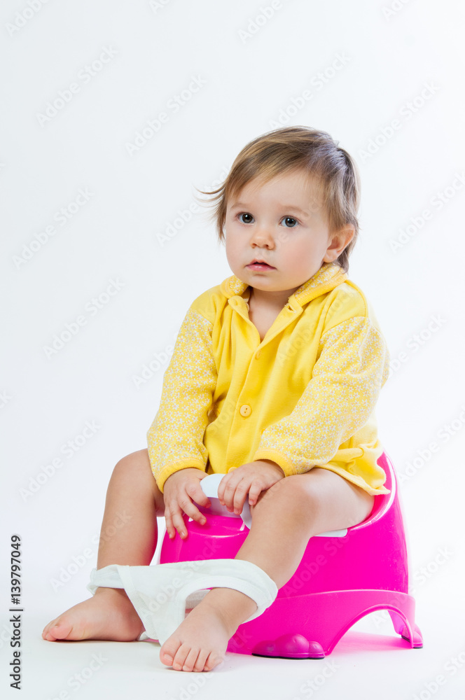Little smiling girl sitting on a pot. Isolated on white background. Little smiling girl sitting on a pot. Isolated on white background.
