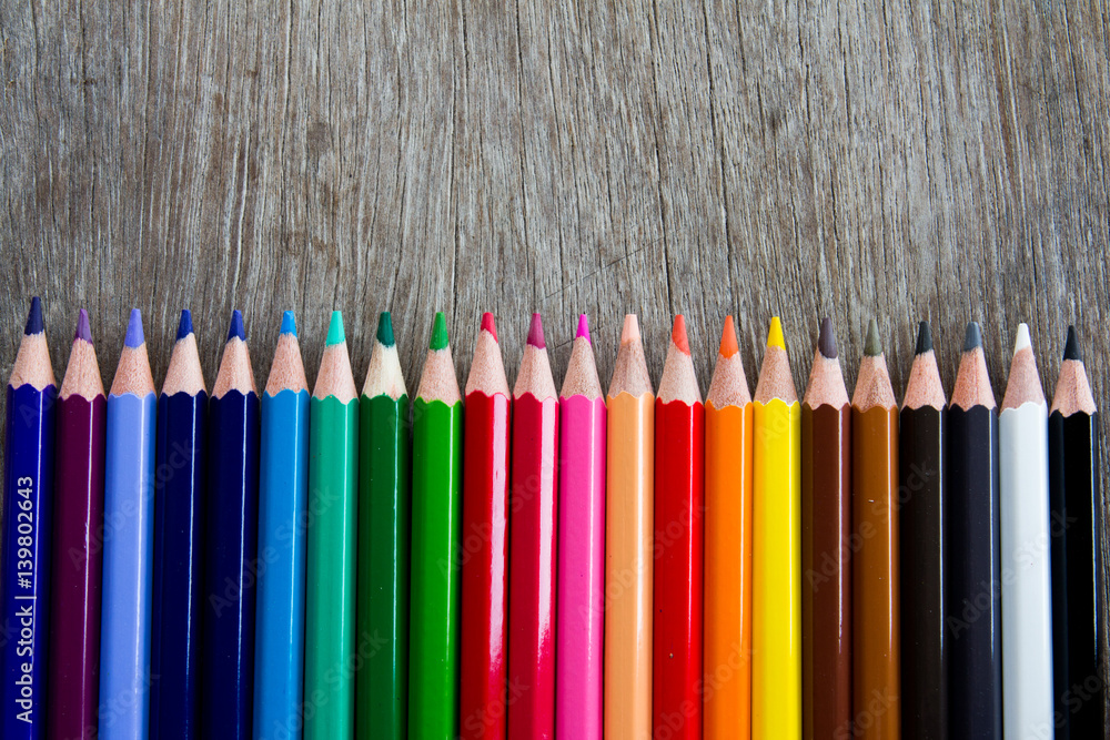 Color pencil row on the wooden background Color pencil row on the wooden background