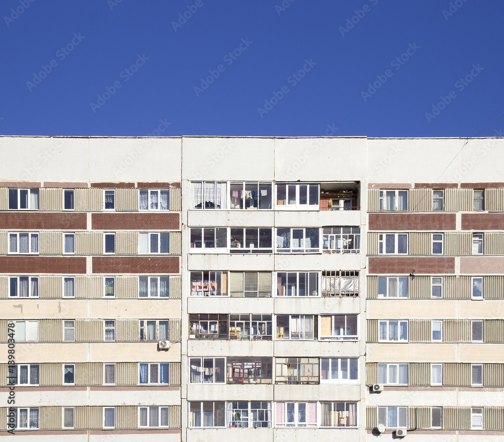 Facade of panel apartment building and blue sky