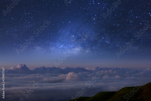 Milky way galaxy over foggy mountains in Thailand. Long exposure photograph.with grain