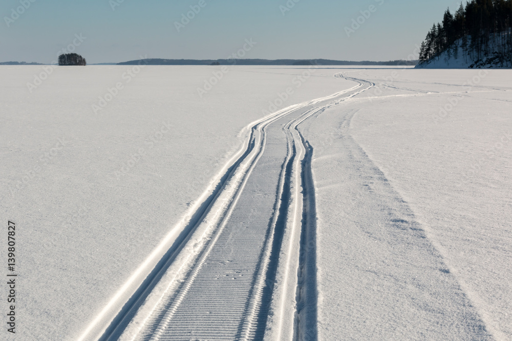 Snowmobile trail on frozen lake