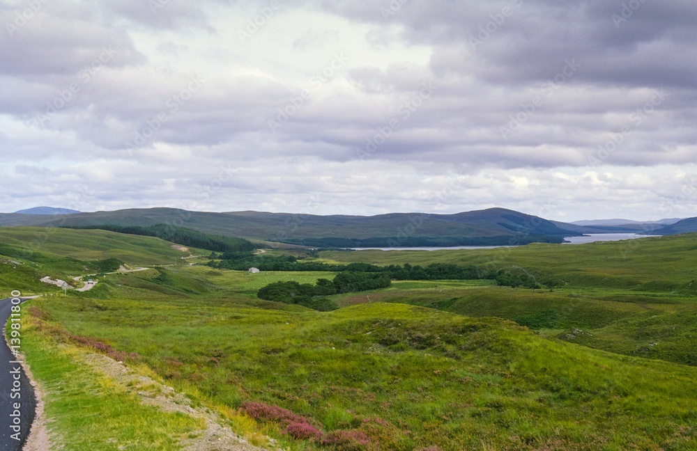 Schmale Landstraße mit Passingplaces schlängelt sich durch die hügelige Landschaft nahe Tongue / Tunga, Council Area Highland, Schottland, Großbritannien, Europa 