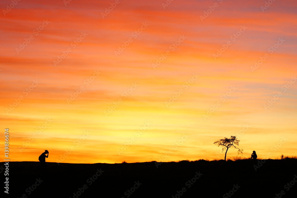 People standing in the field with sunset background