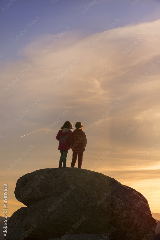 Girls playing at sunset on top of the mountain