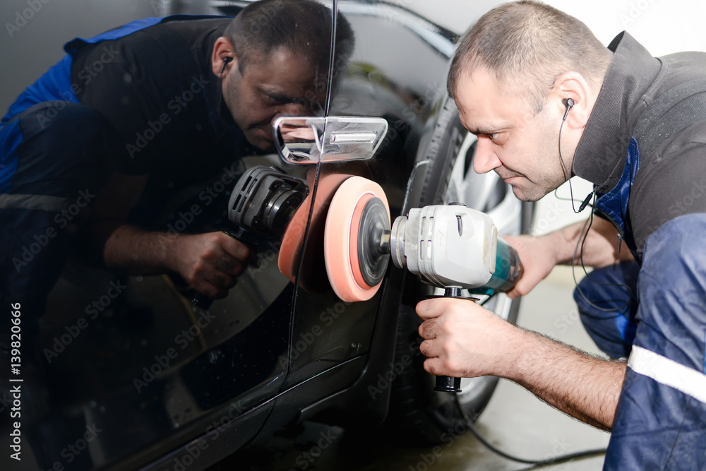 Man on a car wash polishing car with a polish machine Man on a car wash polishing car with a polish machine