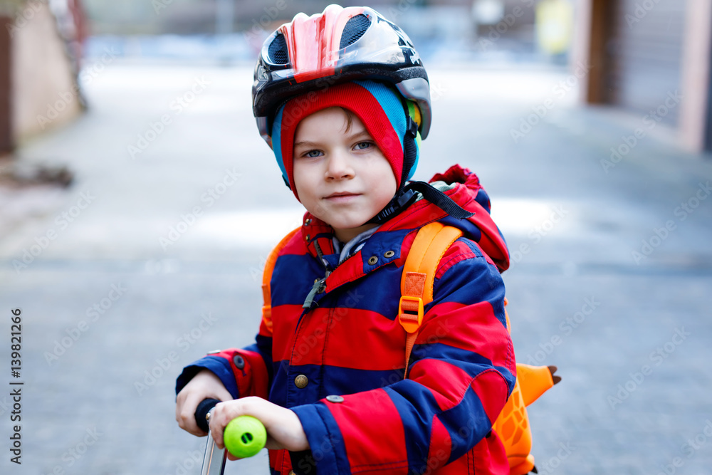 Cute little preschool kid boy riding on scooter riding to school. Cute little preschool kid boy riding on scooter riding to school.