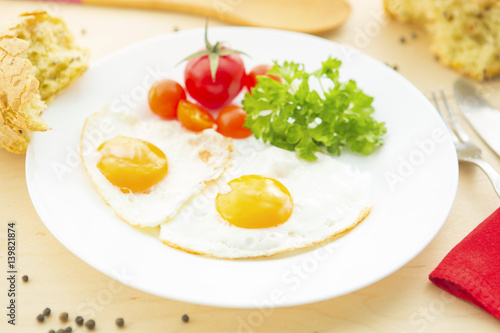 Fried Eggs on a plate on wooden background photo