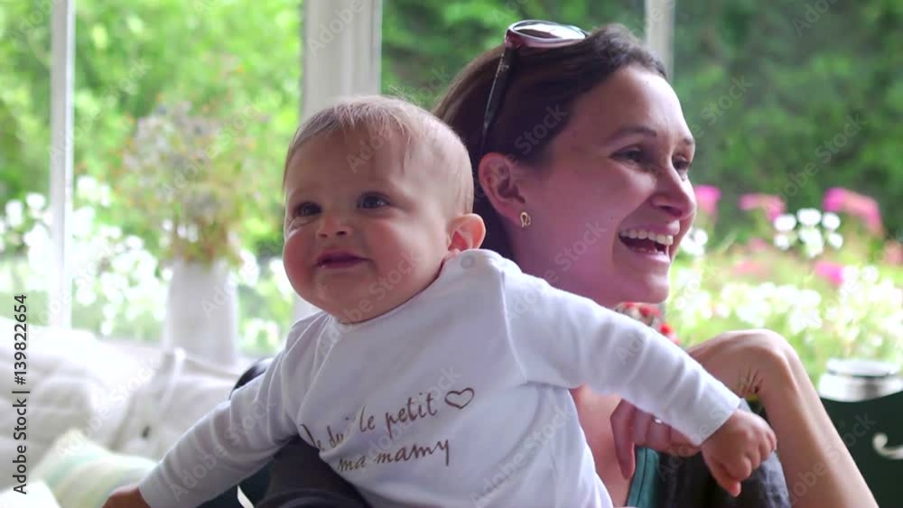 Candid moment of young mom holding her baby toddler in her arms. Young