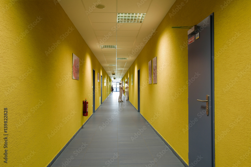 long hospital corridor with yellow walls