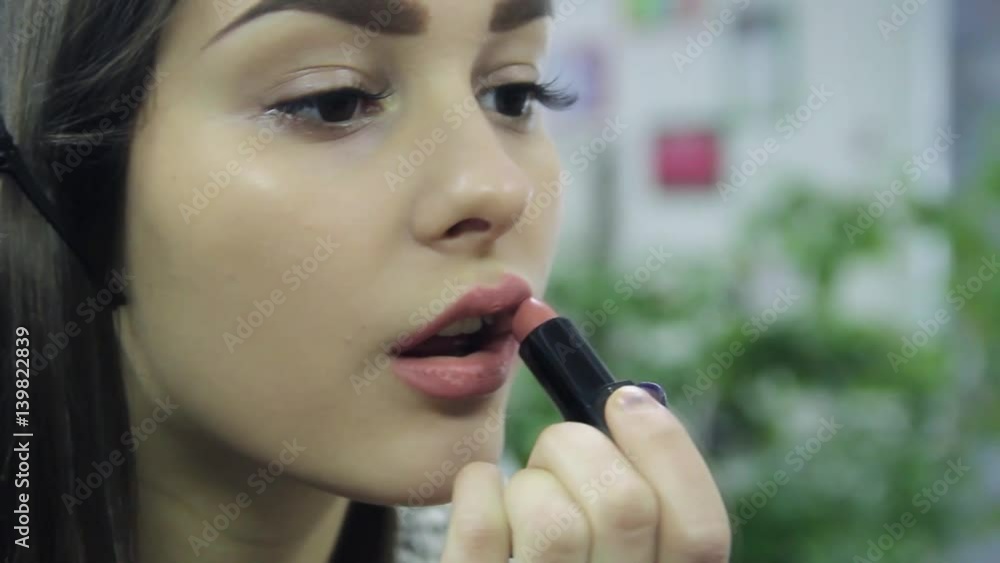 young beautiful model girl applying lipstick young beautiful model girl applying lipstick