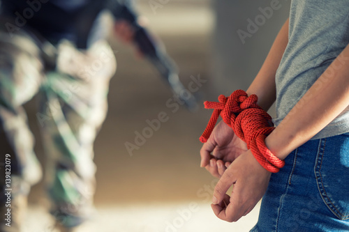 Tied rope hands of abused woman