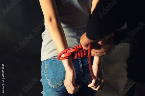 Fototapeta Tied rope hands of abused woman