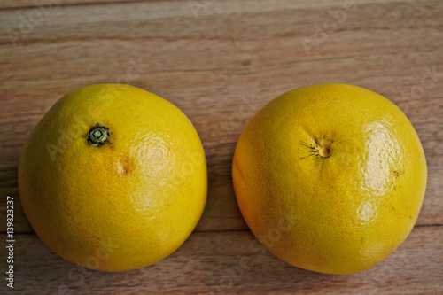 Closeup of two grapefruits on a wooden table