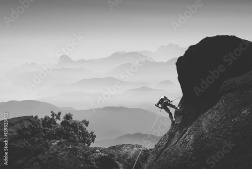 Fototapeta Wspinacz przeciwko górskiej dolinie. Czarny i biały