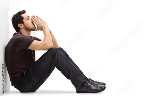 Bild auf Leinwand Pensive man leaning against a wall and thinking
