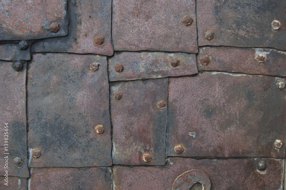 old rusty metal plates nailed up with wrought tacks