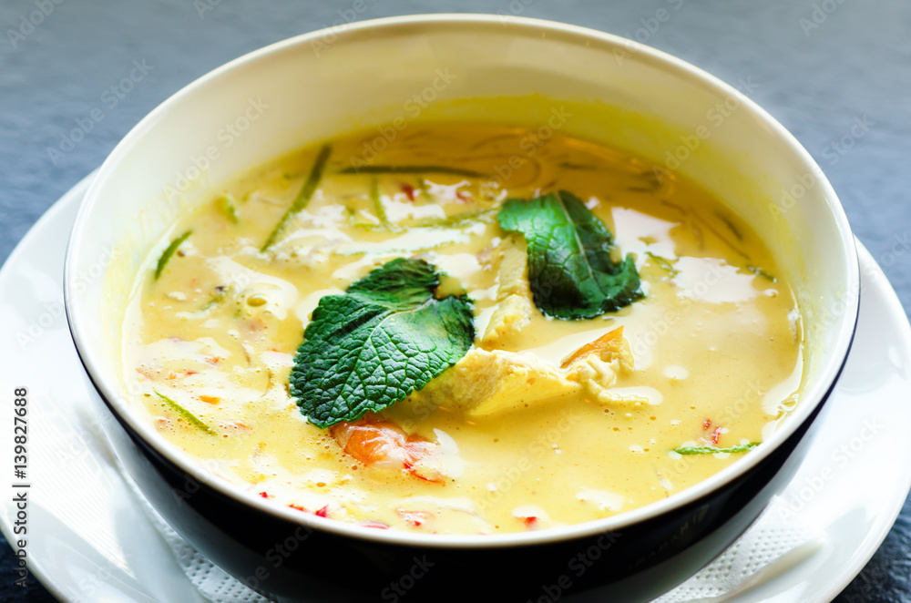 Spicy coconut milk cream soup curry with chiken, tiger prawns, long soy noodles, bean sprouts, lime, chilli pepper and mint. Asian traditional national cuisine, recipe. Copy space Spicy coconut milk cream soup curry with chiken, tiger prawns, long soy noodles, bean sprouts, lime, chilli pepper and mint. Asian traditional national cuisine, recipe. Copy space
