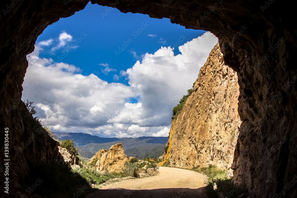 Scenic view through a tunnel to Colca Canyon in springtime and blue sky and white clouds, Peru