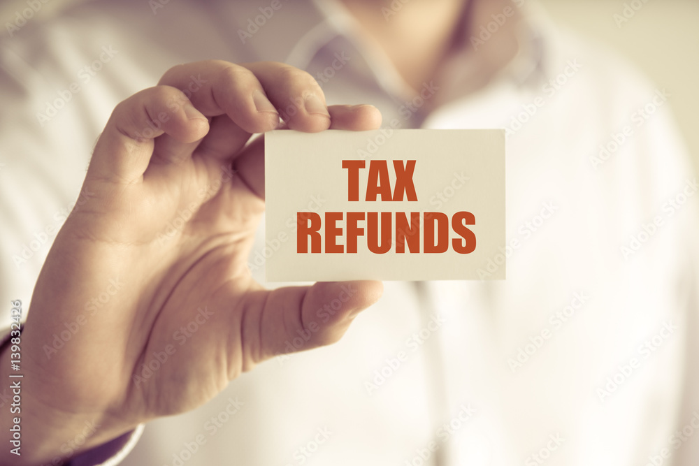 Businessman holding TAX REFUNDS message card Businessman holding TAX REFUNDS message card