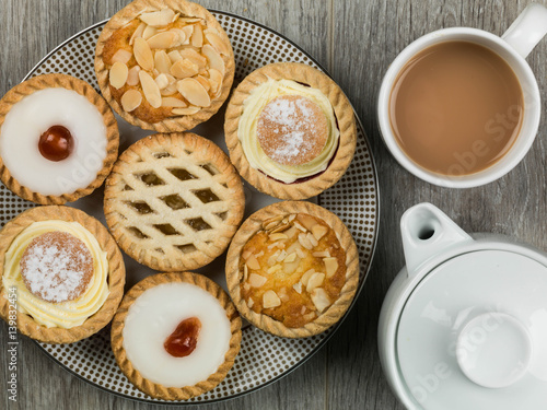 Plate of Assorted Individual Cakes or Tarts With a Pot of Tea