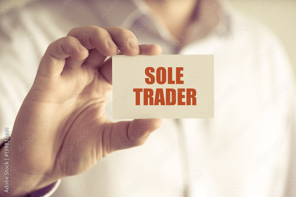 Businessman holding SOLE TRADER message card