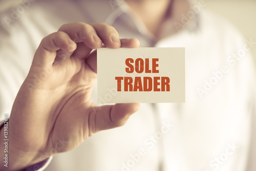 Obraz na płótnie Businessman holding SOLE TRADER message card w salonie