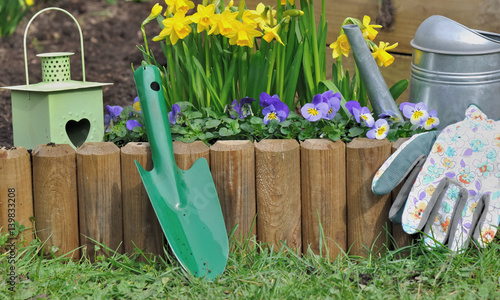accessoires de jardin devant bordure en bois fleurie