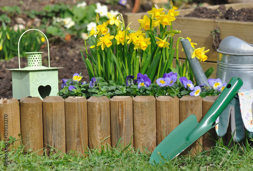 Quadro su tela accessoires de jardin devant bordure en bois fleurie