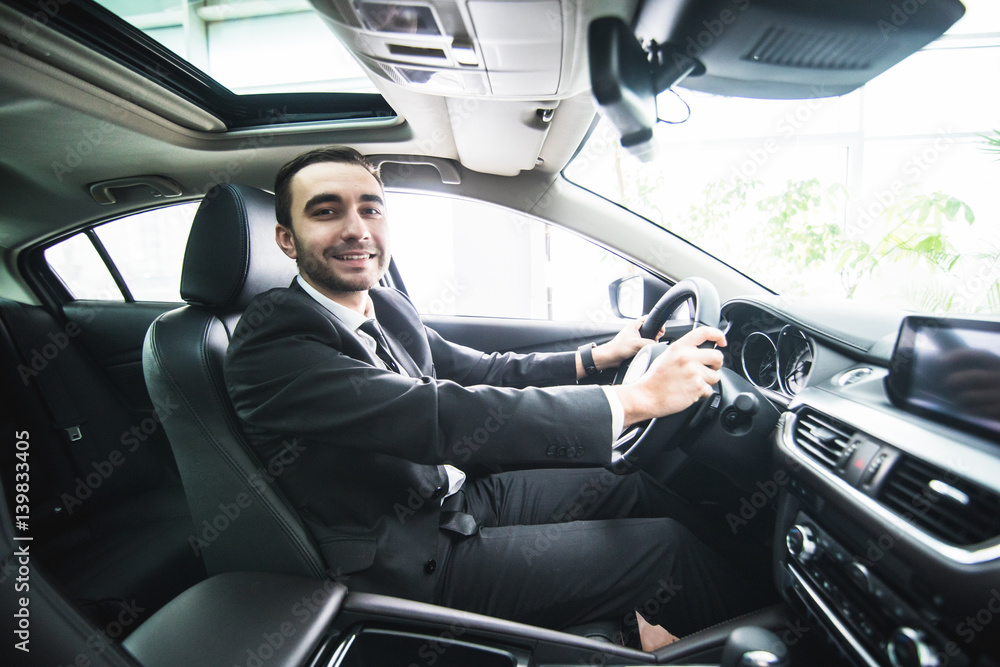 Driving with pleasure. Close-up of cheerful mature man in formalwear driving car and smiling Driving with pleasure. Close-up of cheerful mature man in formalwear driving car and smiling