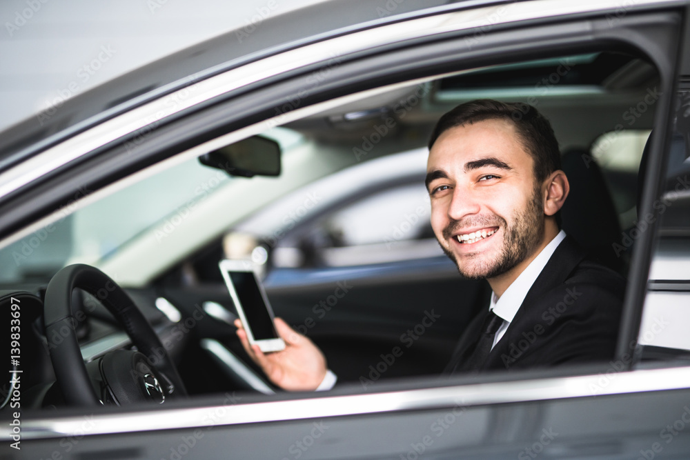Businessman in car use smartphone and smile on camera