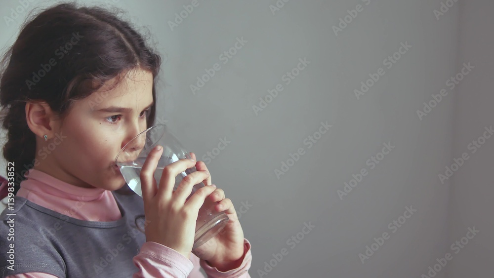 teen girl drinks water from a glass cup the indoor teen girl drinks water from a glass cup the indoor