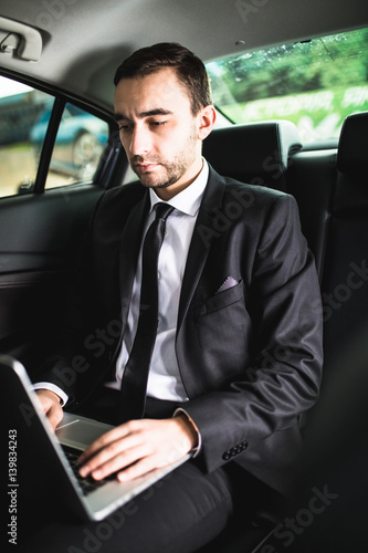 Handsome young businessman working on his laptop while sitting in the car © F8  \ Suport Ukraine