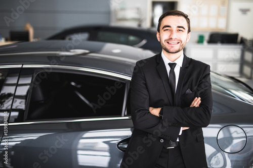 Handsome young classic car salesman standing at the dealership © F8  \ Suport Ukraine