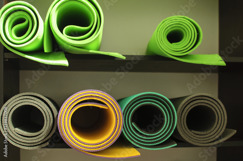 Few rolls of mat for yoga, pilates and fitness on the shelf at the gym,  horizontal image photo