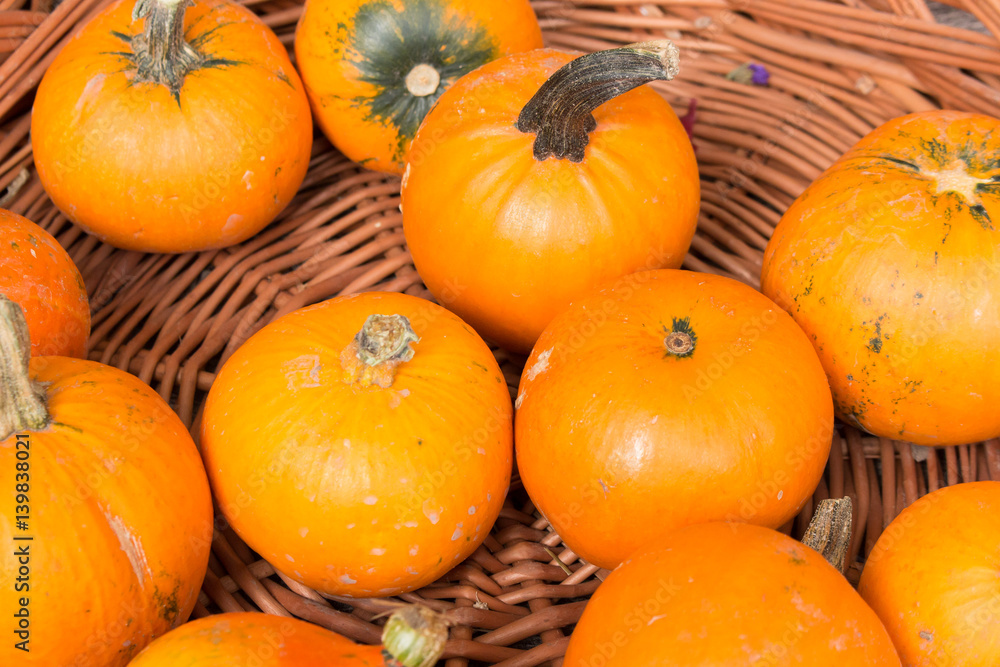 orange pumpkins on a pile in a wooden basket orange pumpkins on a pile in a wooden basket