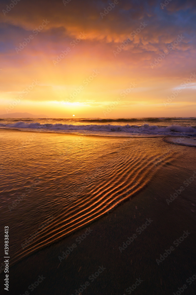 beach shore at sunset with water ripples