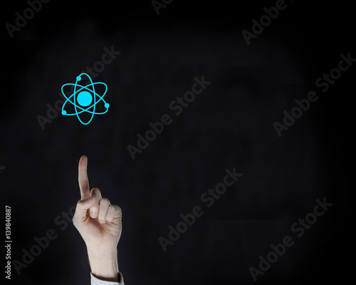 finger on the black background and the atom icon