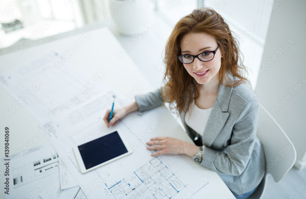 Beautiful female architect working on plan Beautiful female architect working on plan