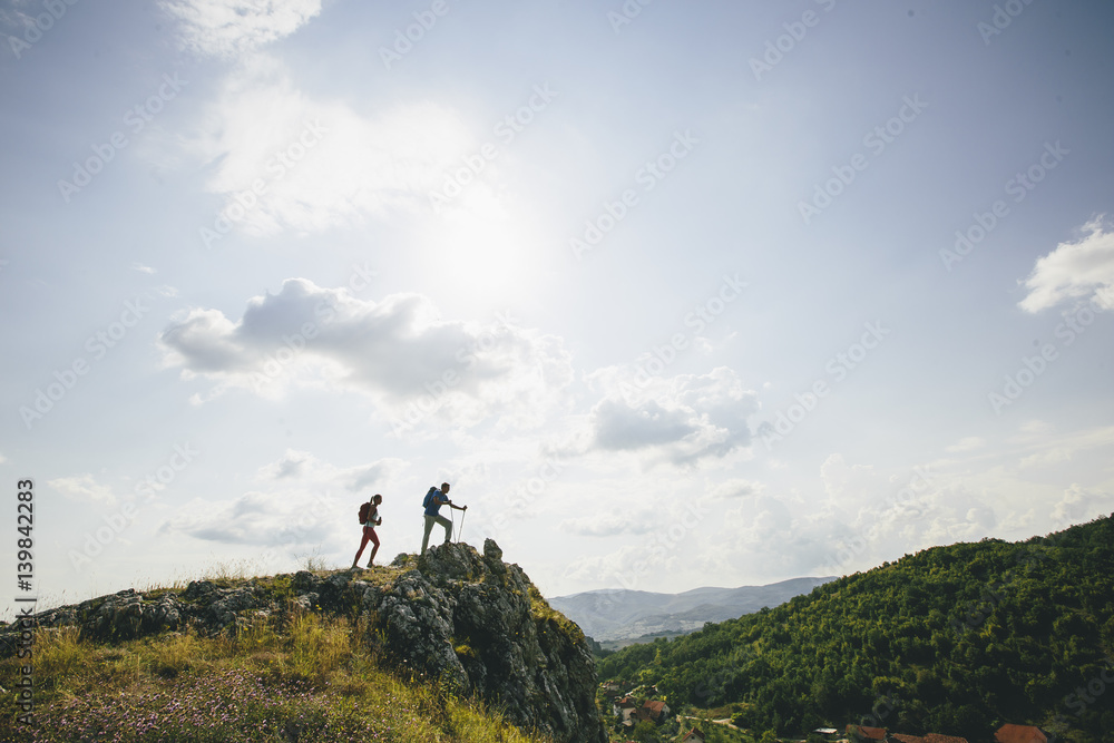 Hikers with backpacks walking on top of a mountain and enjoy hiking