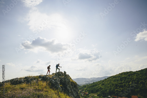 Hikers with backpacks walking on top of a mountain and enjoy hiking