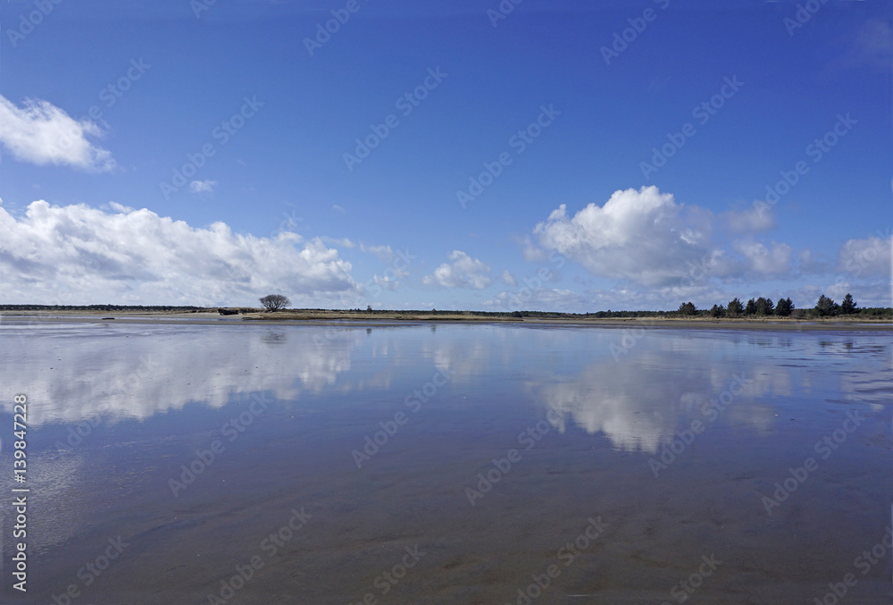 Low tide reflections in tidal flats at Fort Stevens state park in Warrenton Oregon on the Columbia river