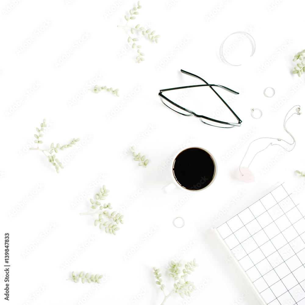 Coffee cup, notebook, glasses, green branches and female accessories on white background. Flat lay, top view