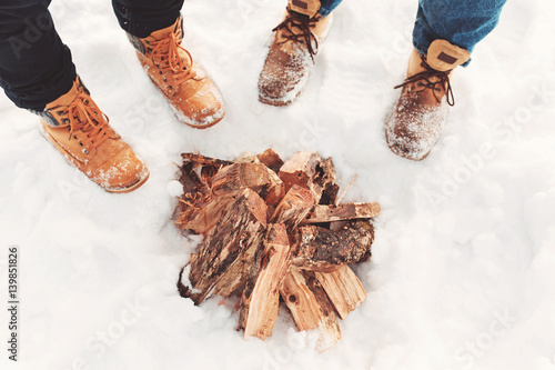 Εκτύπωση καμβά Two people stand in the snow near campfire