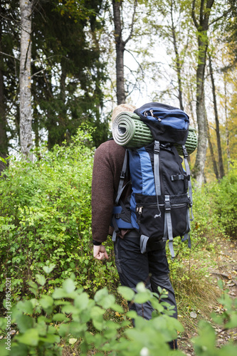 Man With Backpack Hiking In Forest