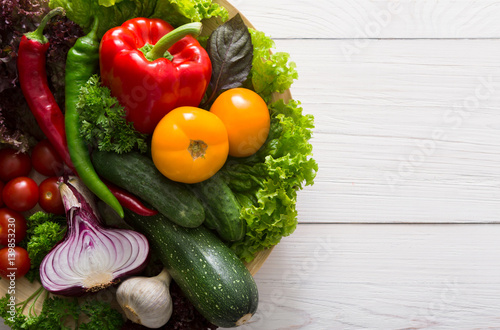 Border of fresh vegetables on wooden background with copy space