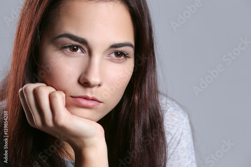 Depressed young woman on color background  closeup