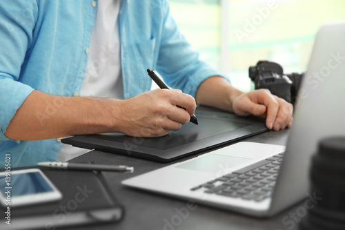 Photographer working with graphics tablet in office